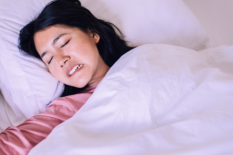 Young woman grinding her teeth in her sleep